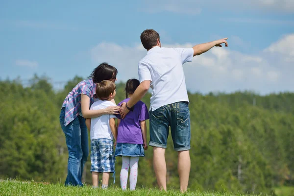 幸せな若い家族が屋外に楽しい時を過す — Stock fotografie