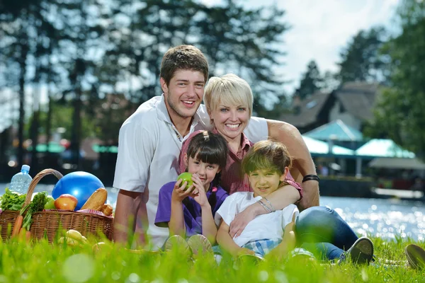 Lycklig familj spelar tillsammans i en picknick utomhus — Stockfoto