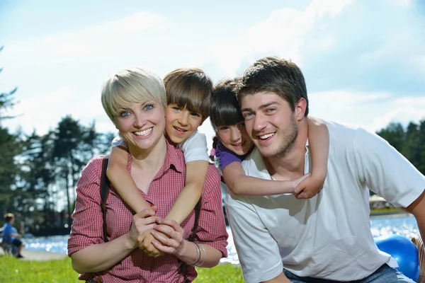 Щаслива молода сім'я розважається на відкритому повітрі — стокове фото
