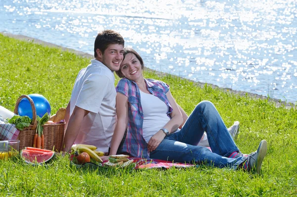 Feliz pareja joven teniendo un picnic al aire libre — Foto de Stock