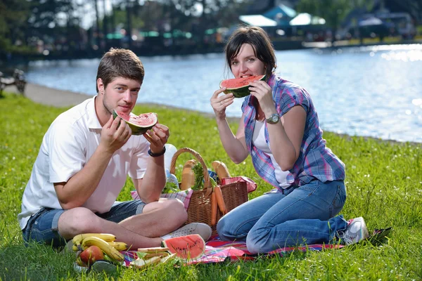 Feliz pareja joven teniendo un picnic al aire libre —  Fotos de Stock