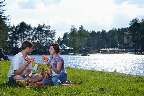 Счастливая молодая пара устраивает пикник на открытом воздухе — стоковое фото