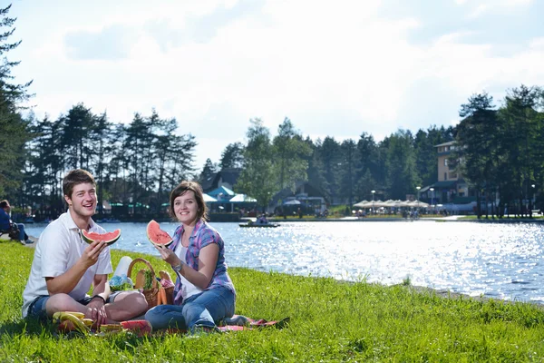Feliz jovem casal fazendo um piquenique ao ar livre — Fotografia de Stock