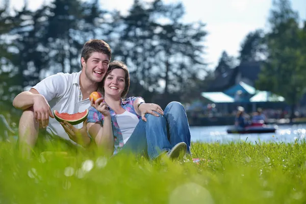 Happy young couple having a picnic outdoor — Stockfoto