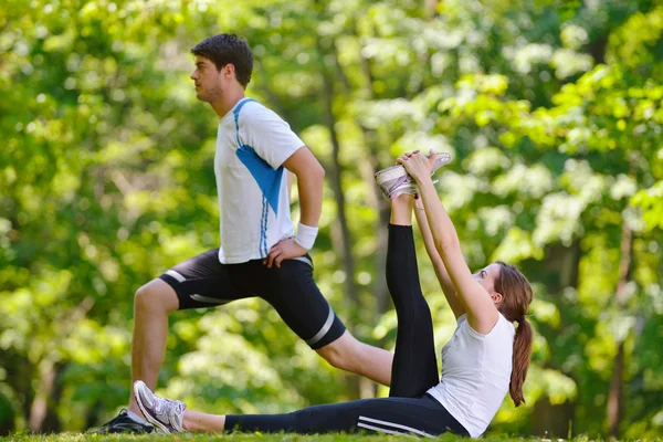 Couple doing stretching exercise after jogging Stock Photo