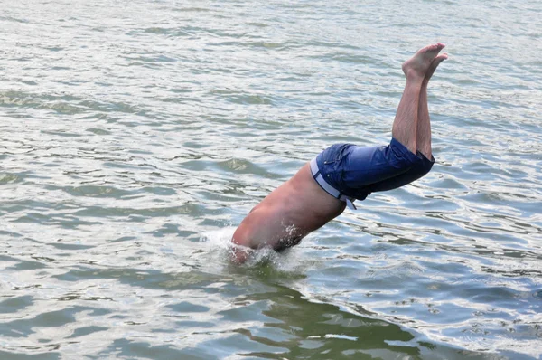 Человек погружается в воду — стоковое фото