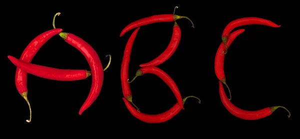 Letters from red chili peppers isolated on black — Stock Photo, Image