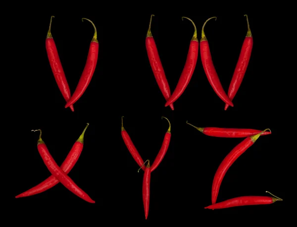 Five letters from chili peppers on black — Stock Photo, Image