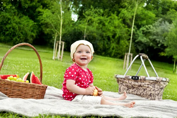 Baby op picnic met vruchten — Stockfoto