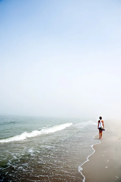 Kvinde på vandring ved havet - Stock-foto