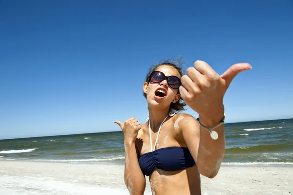 Kobieta na piasku ok kciukiem — Zdjęcie stockowe