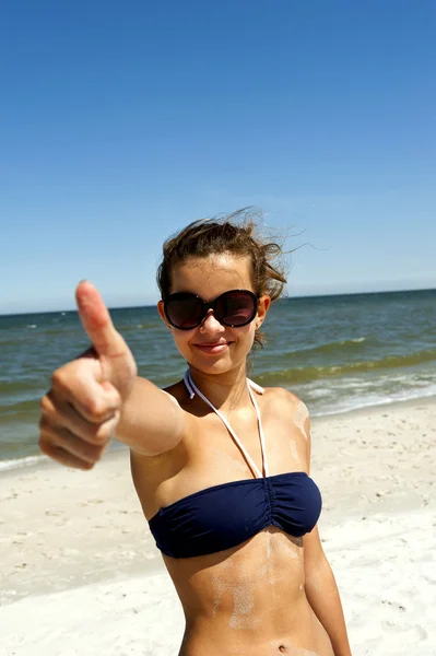 Žena na písku s ok palec — Stock fotografie