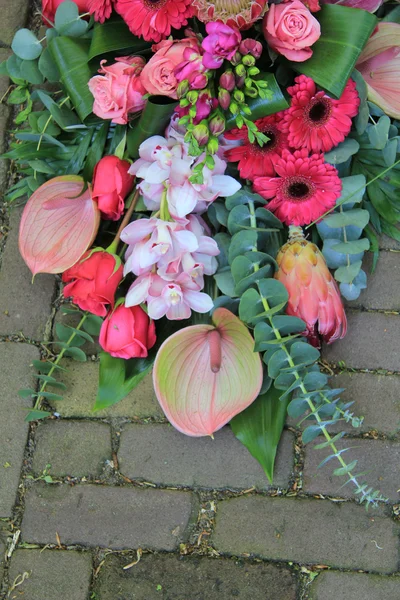 Pink sympathy bouquet on pavement — Stock Photo, Image