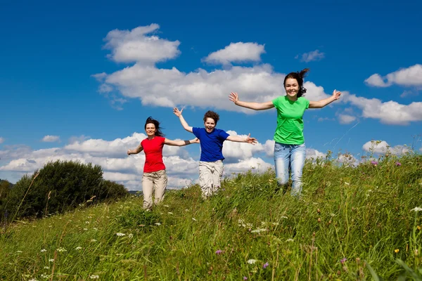 Aktiv familj - mor och barn springa, hoppa utomhus — Stockfoto