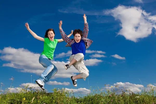 Dívka a chlapec běh, skákání venkovní — Stock fotografie