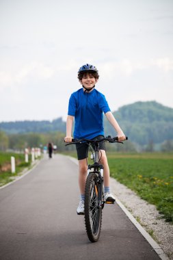 Boy biking on cycle lane clipart