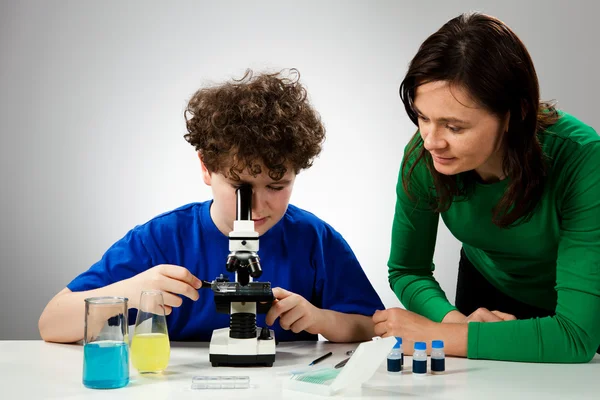 Garçon examinant la préparation au microscope — Photo