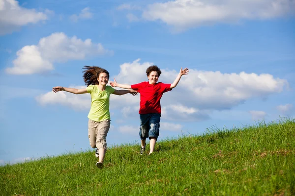 Mädchen und Junge rennen, springen im Freien — Stockfoto