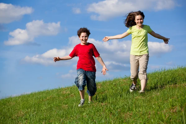 Meisje en jongen lopen, springen buiten — Stockfoto