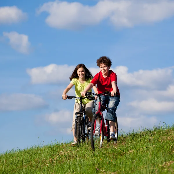 Menina e menino de bicicleta — Fotografia de Stock