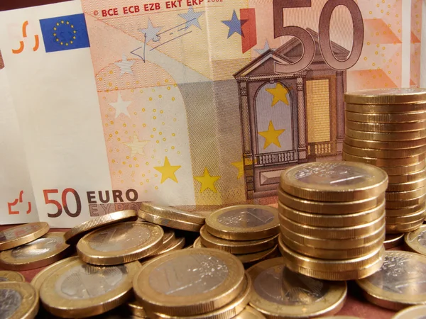 Monedas en euros sobre fondo de dinero de billetes —  Fotos de Stock