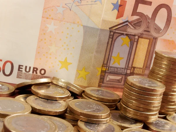 Pièces en euros sur fond de billets de banque — Photo