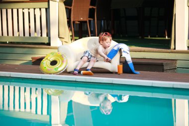 Adorable boy at the swimming pool clipart