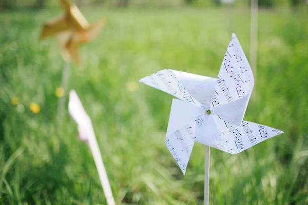 Paper windmill in green grass field — Stock Photo, Image