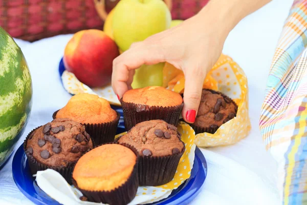 Female hand picking a muffin — Stock Photo, Image