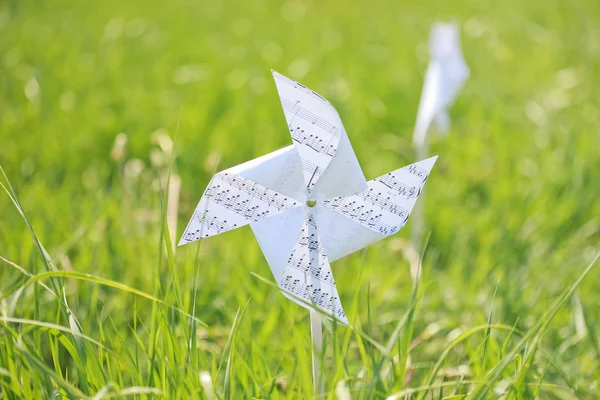 Paper windmill in green grass field — Stock Photo, Image