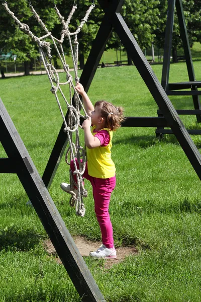 Küçük kız oyun bahçesinde oynuyor. — Stok fotoğraf