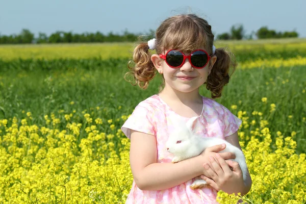Petite fille tenant lapin nain blanc — Photo