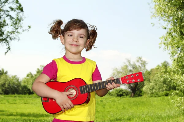 Little girl with guitar in park — Stock Photo, Image
