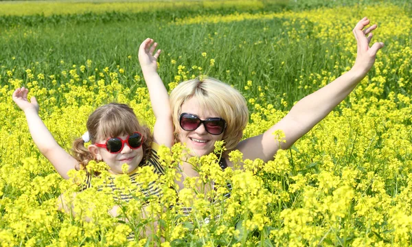 Mother and daughter in yellow flower field — Stock Photo, Image