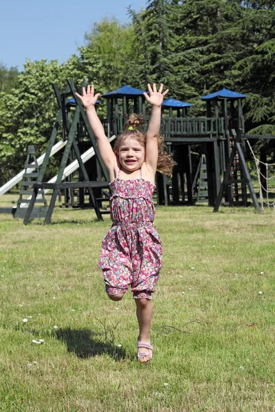 Маленькая девочка прыгает на детской площадке — стоковое фото