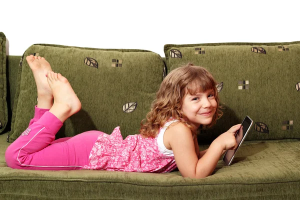 Happy little girl lying on bed with tablet — Stock Photo, Image