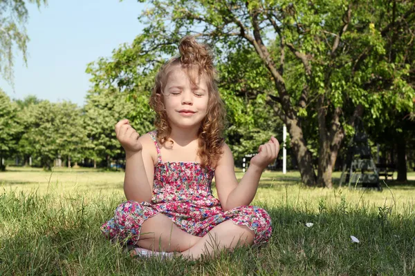 Liten flicka mediterar i naturen — Stockfoto