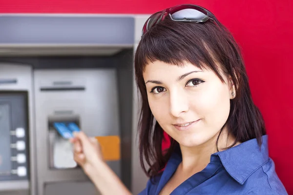 Žena vybírá peníze z kreditní karty v bankomatu — Stock fotografie