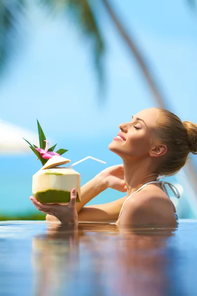 Mulher relaxante na piscina com um cocktail — Fotografia de Stock