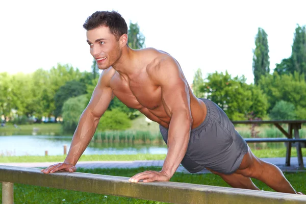 Fitnessmann im Park macht Liegestütze — Stockfoto