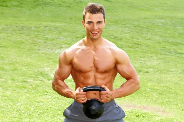 Muscular hombre sosteniendo kettlebell — Foto de Stock