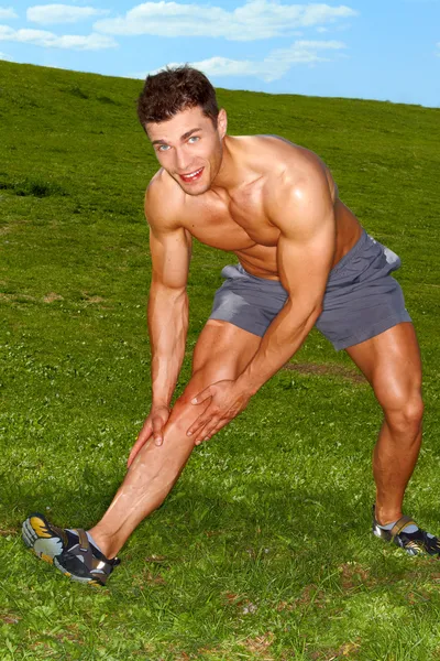 Bonito homem fazendo exercícios de alongamento — Fotografia de Stock