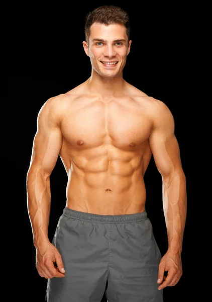 Портрет мускулистого спортсмена, стоящего на черном — стоковое фото