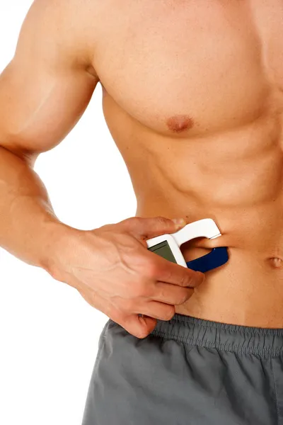 Sportovní muž měří úroveň tuku na těle — Stock fotografie