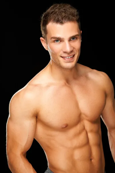 黒に分離されたハンサムな筋肉の若い男 — ストック写真