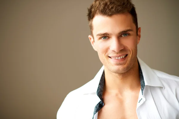 Feliz hombre sonriente posando en camisa blanca —  Fotos de Stock