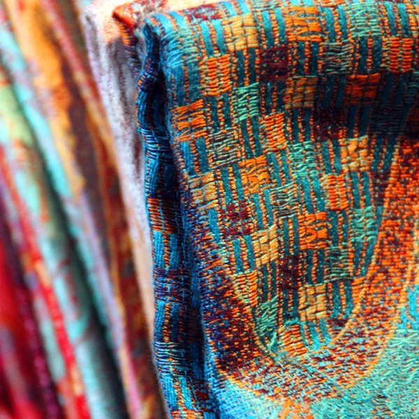 Multicolor fabric, material, shawls and scarves folded — Stock Photo, Image