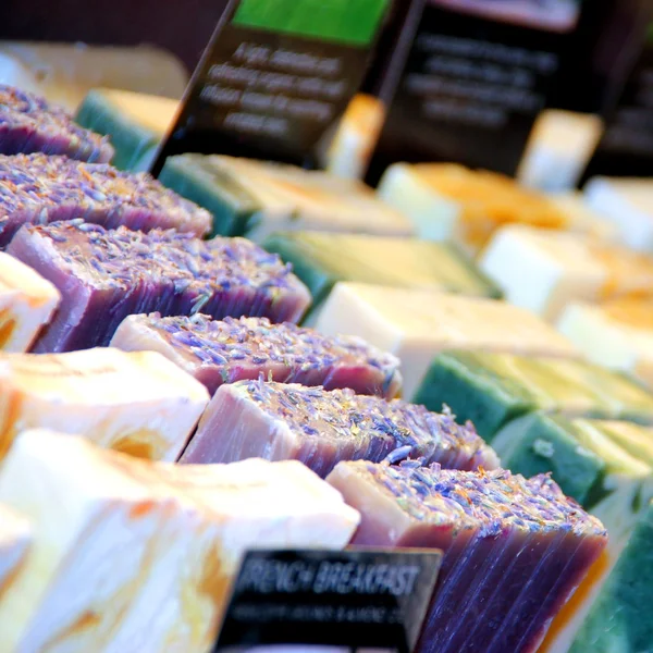 Rows of handmade soap displayed in a retail market — Stock Photo, Image