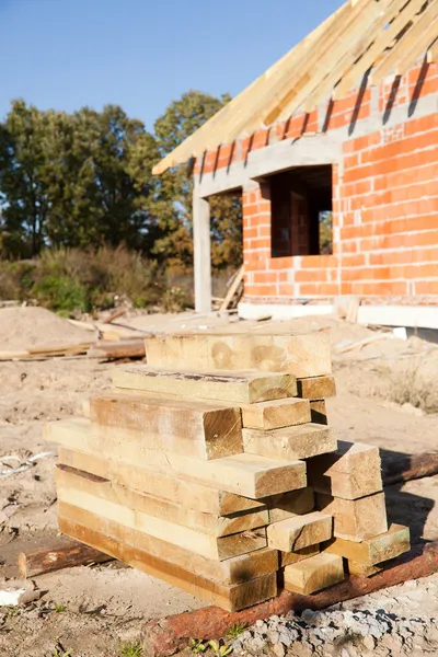 Holzbohlen und unfertiges Haus — Stockfoto