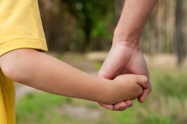 Mother holding a hand of his son outdoors — Stock Photo, Image